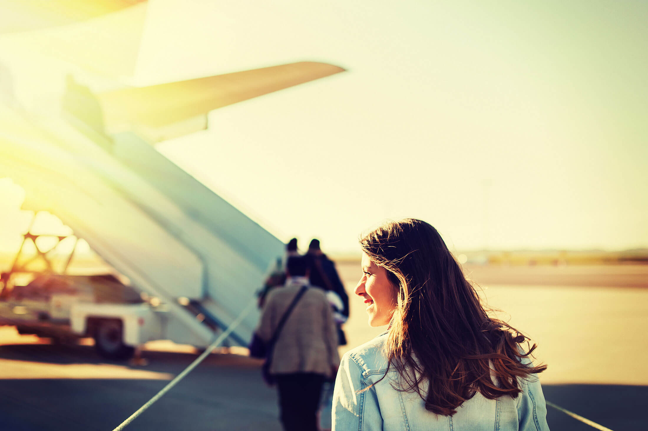 En kvinna är påväg att stiga på ett flyg och i starten av en resa. 