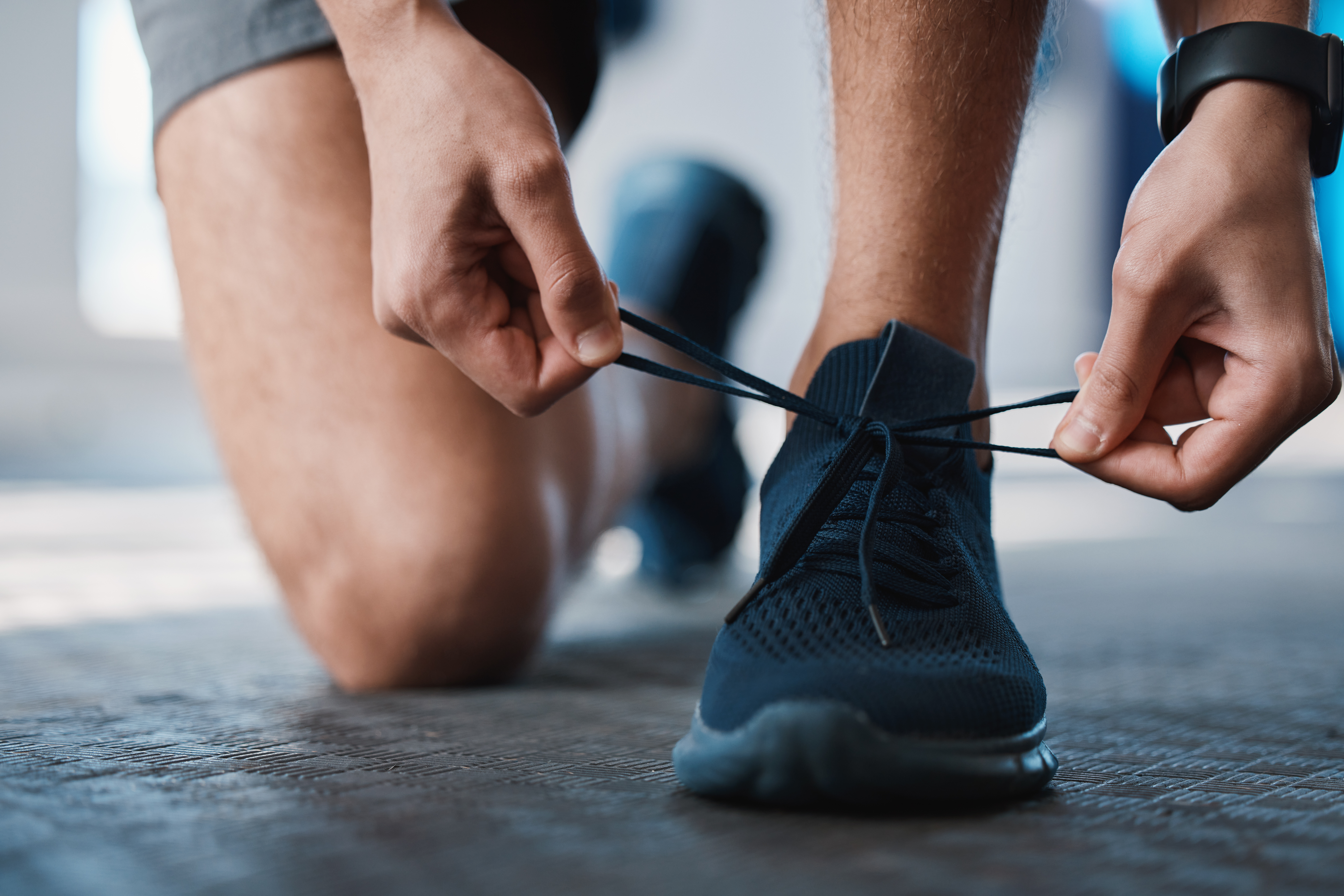 En person knyter skorna och gör sig redo för träning. 