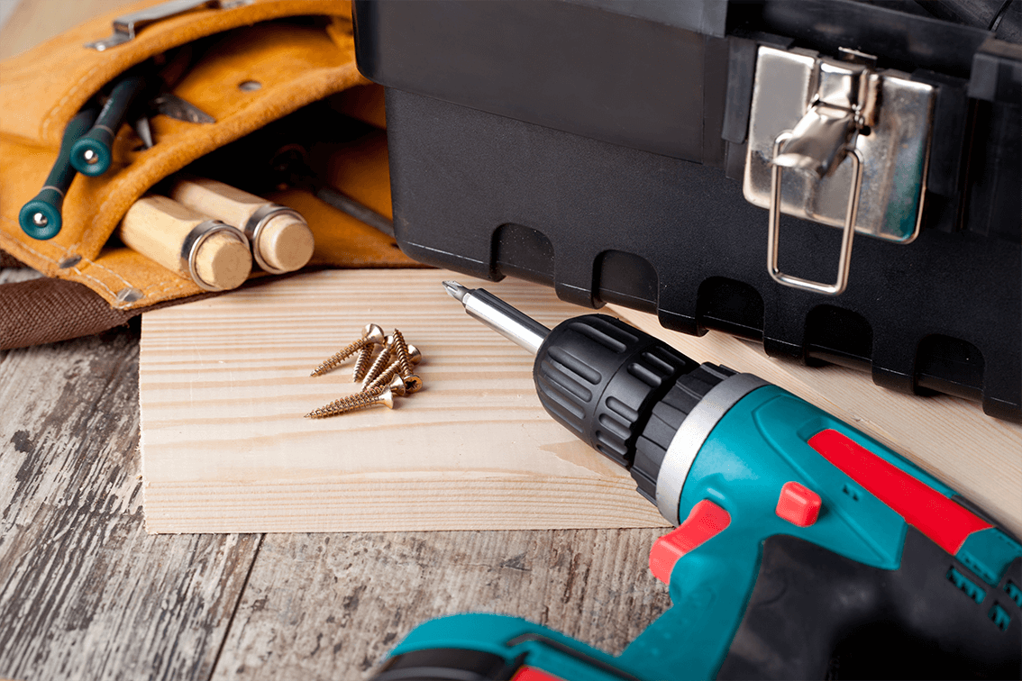 Material inför en renovering såsom skruvar, skruvmejsel, brädor och en verktygslåda